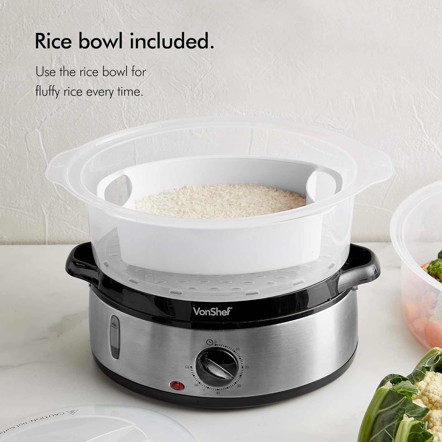 A clear plastic steaming tier with a white rice bowl inside, filled with uncooked white rice.