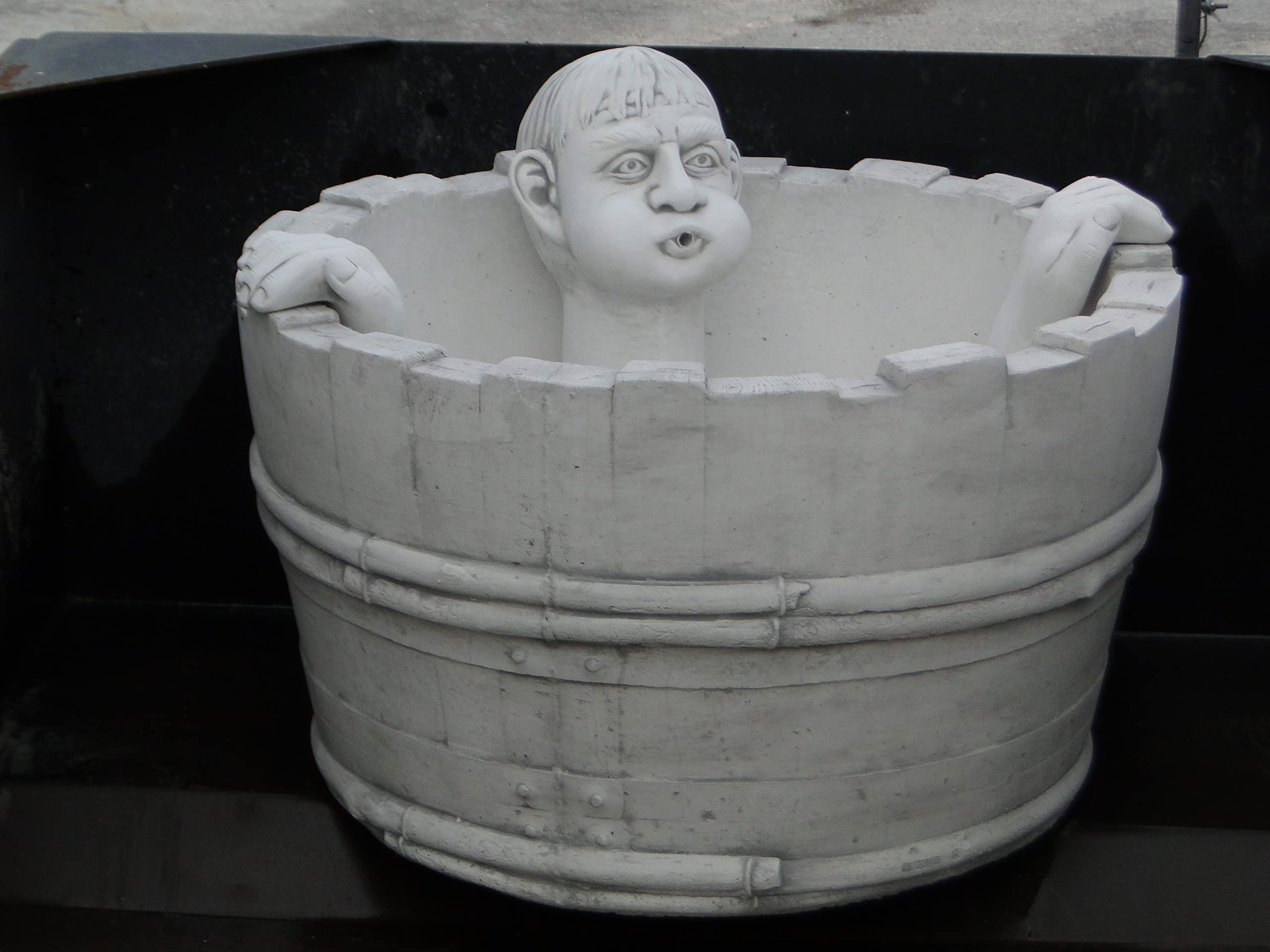 Fontana da giardino, piccolo stagno, con circuito d'acqua chiuso, in pietra fusa, uomo che fa il bagno nella vasca.