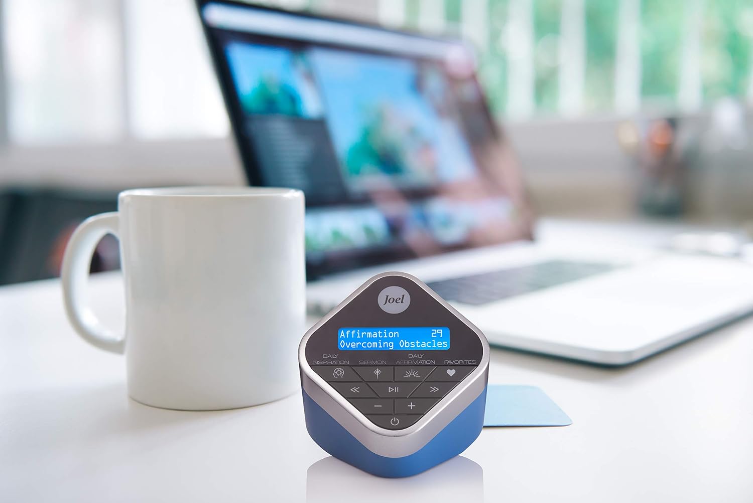 Joel Osteen Inspiration Audio Cube on a desk next to a laptop and coffee mug.