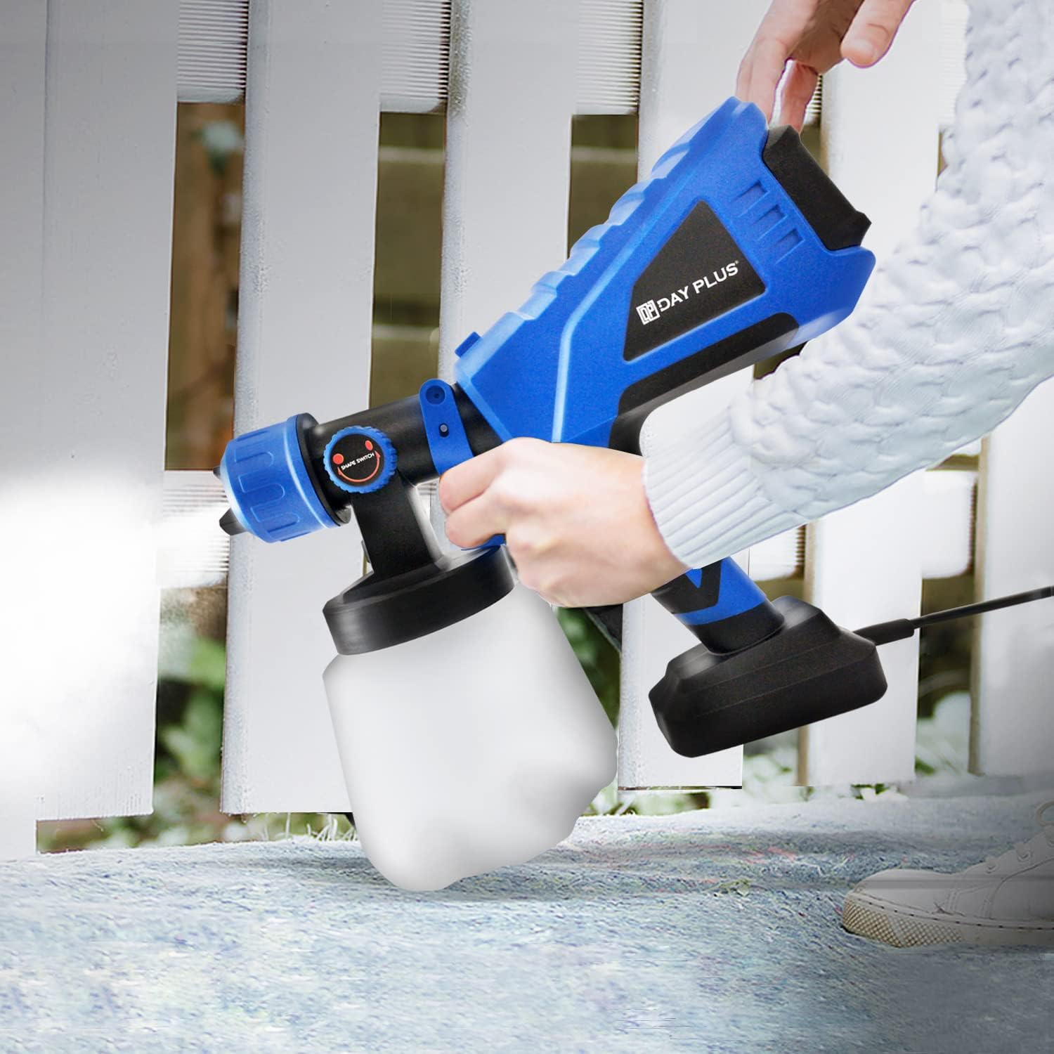 Person spraying a fence with the EFAN paint sprayer