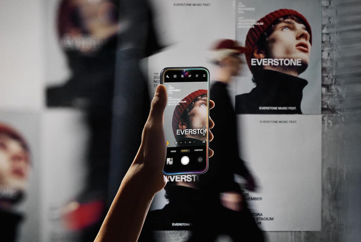 User holding the OnePlus 15 to take a photo of a poster, demonstrating the camera's capability.