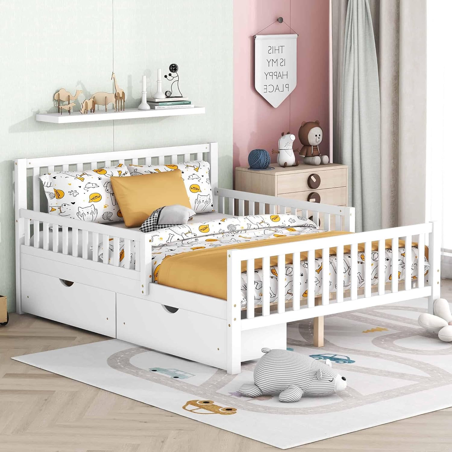 A white full-size wood platform bed with guardrails on both sides and two storage drawers, set in a child's bedroom with colorful decor.