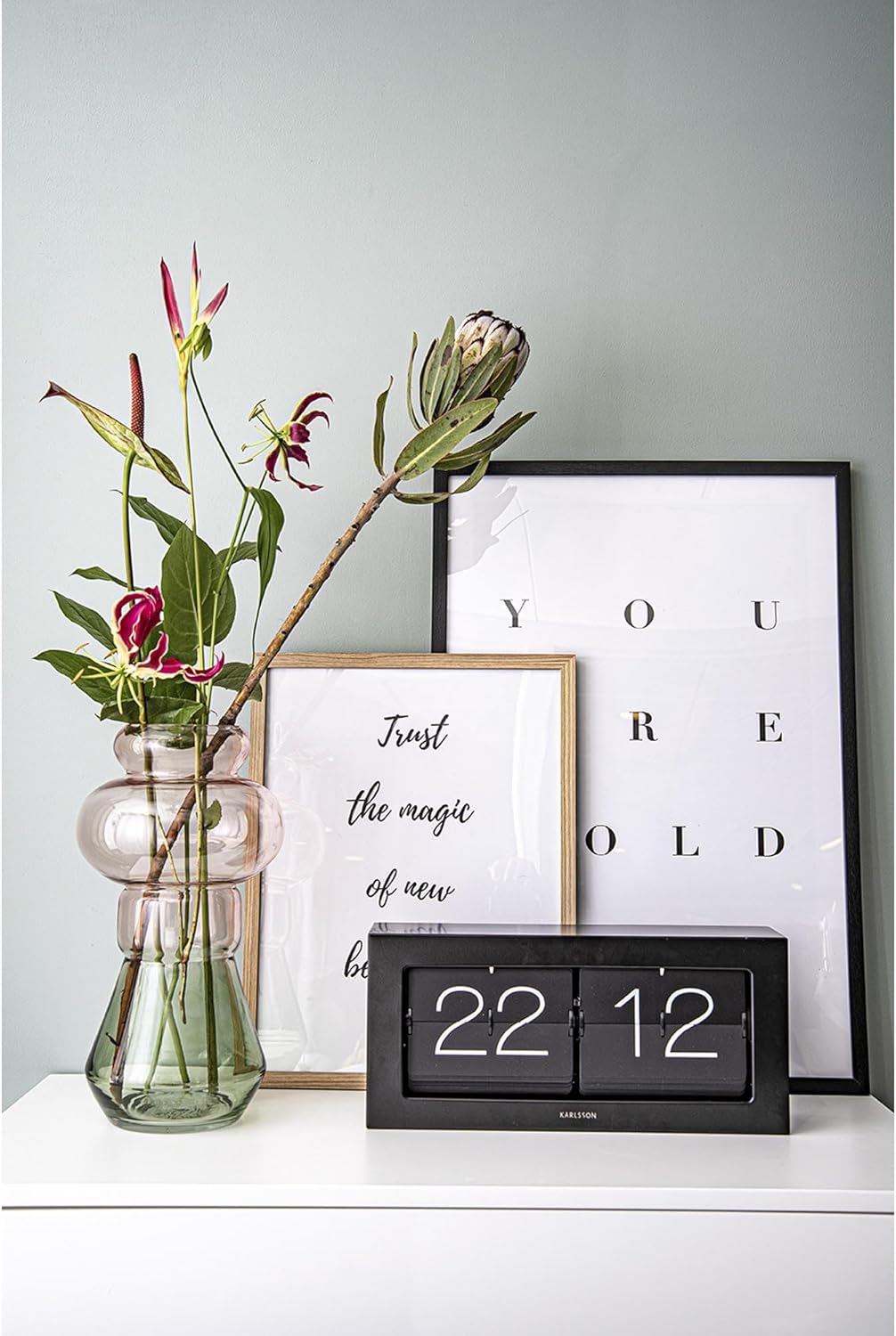 Karlsson KA5642BK Flip Box Table Clock in a home setting, next to a vase and framed pictures