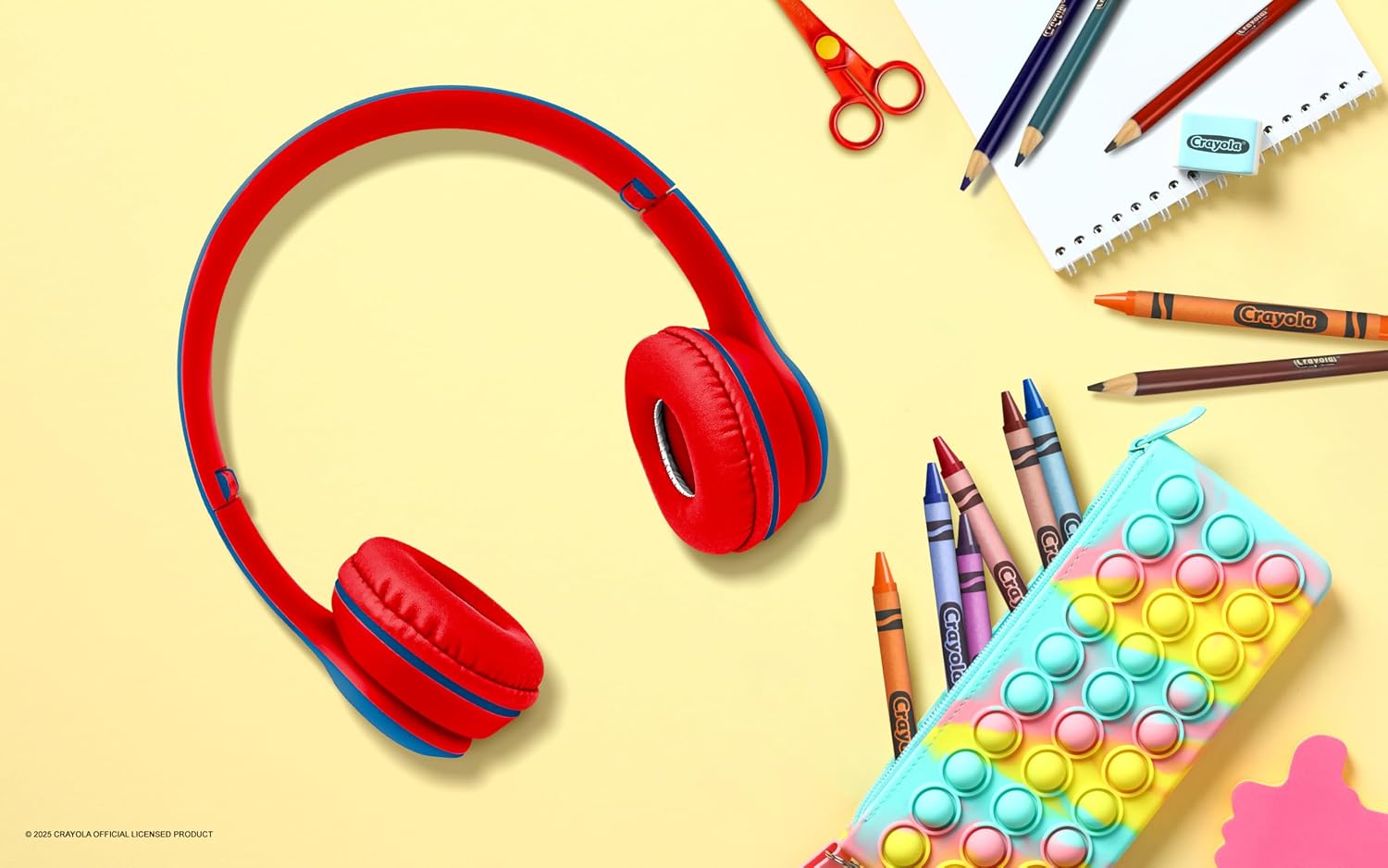 Crayola Kids Wireless Over-Ear Headphones on a desk with school supplies