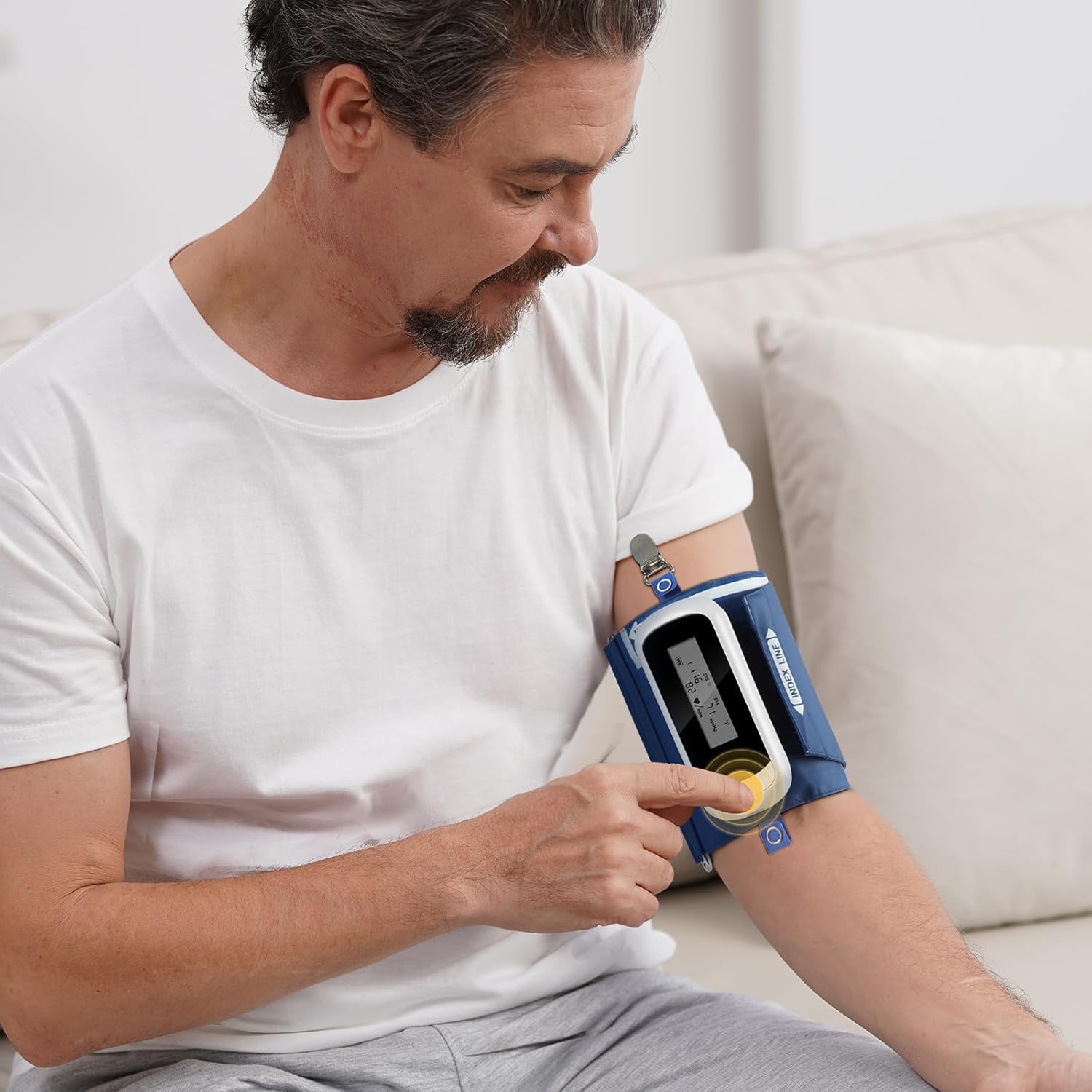 A man pressing a button on the Wellue ABPM device worn on his arm.