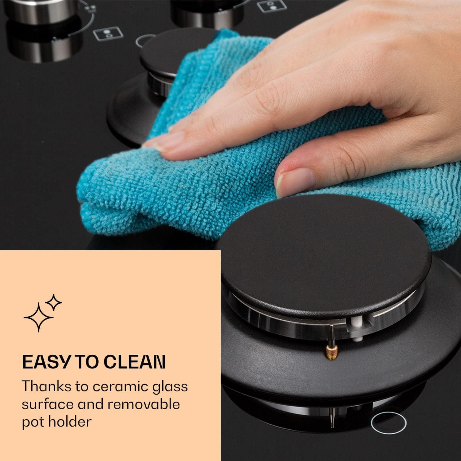 Hand wiping the ceramic glass surface of the gas hob