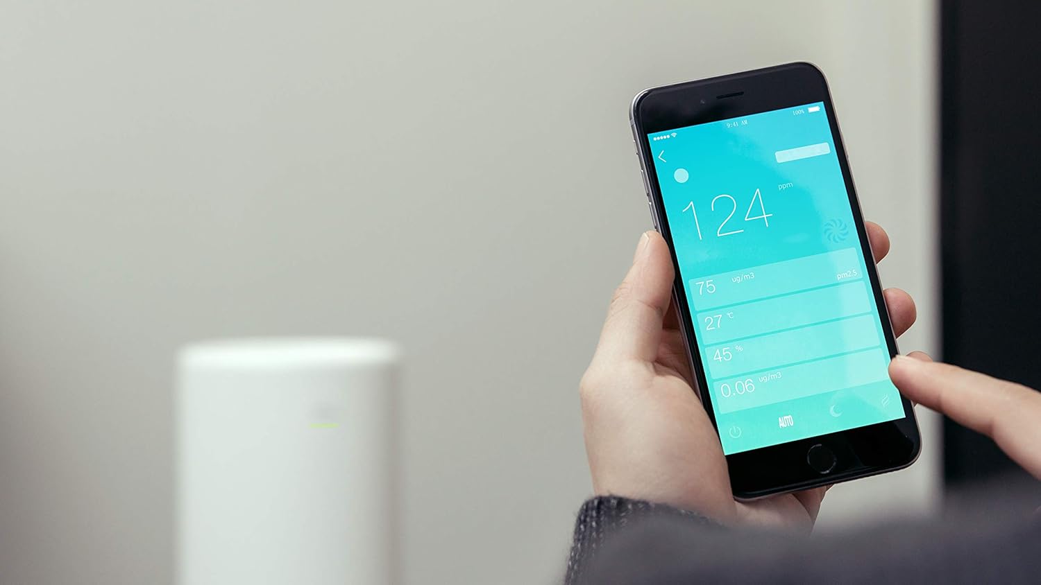 Hand holding a smartphone displaying the LIFAair app interface with air quality readings