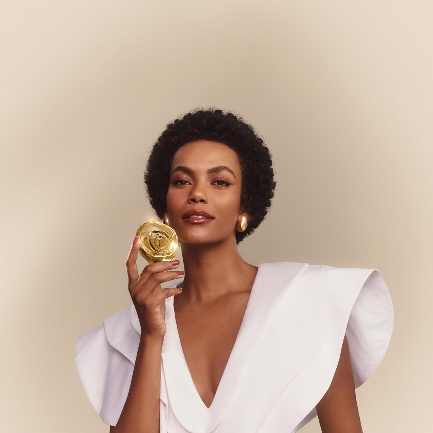 Woman holding Natura Aura Alba Eau de Parfum bottle near her face