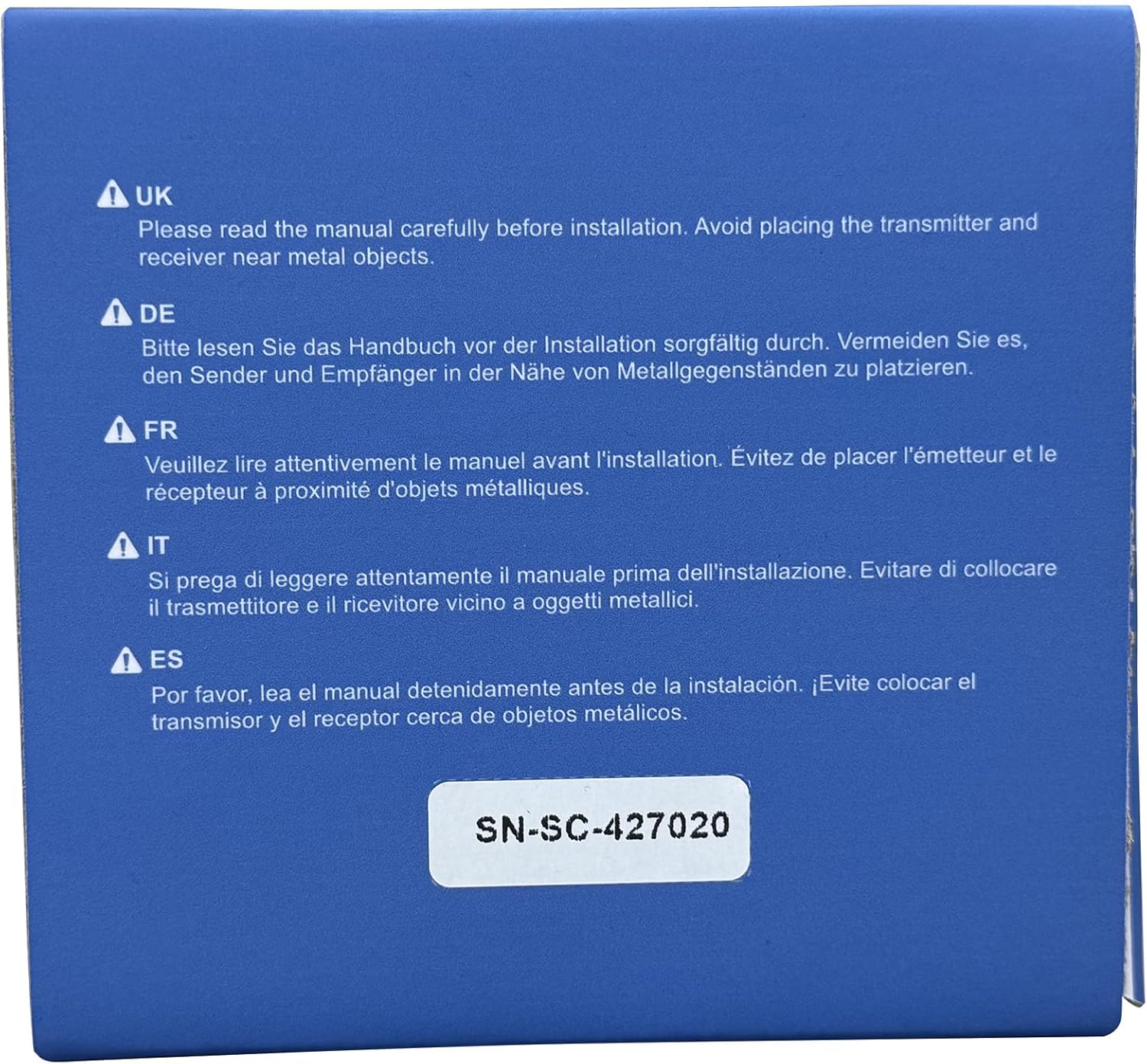 Warning label advising to read manual carefully before installation and to avoid placing transmitter and receiver near metal objects.