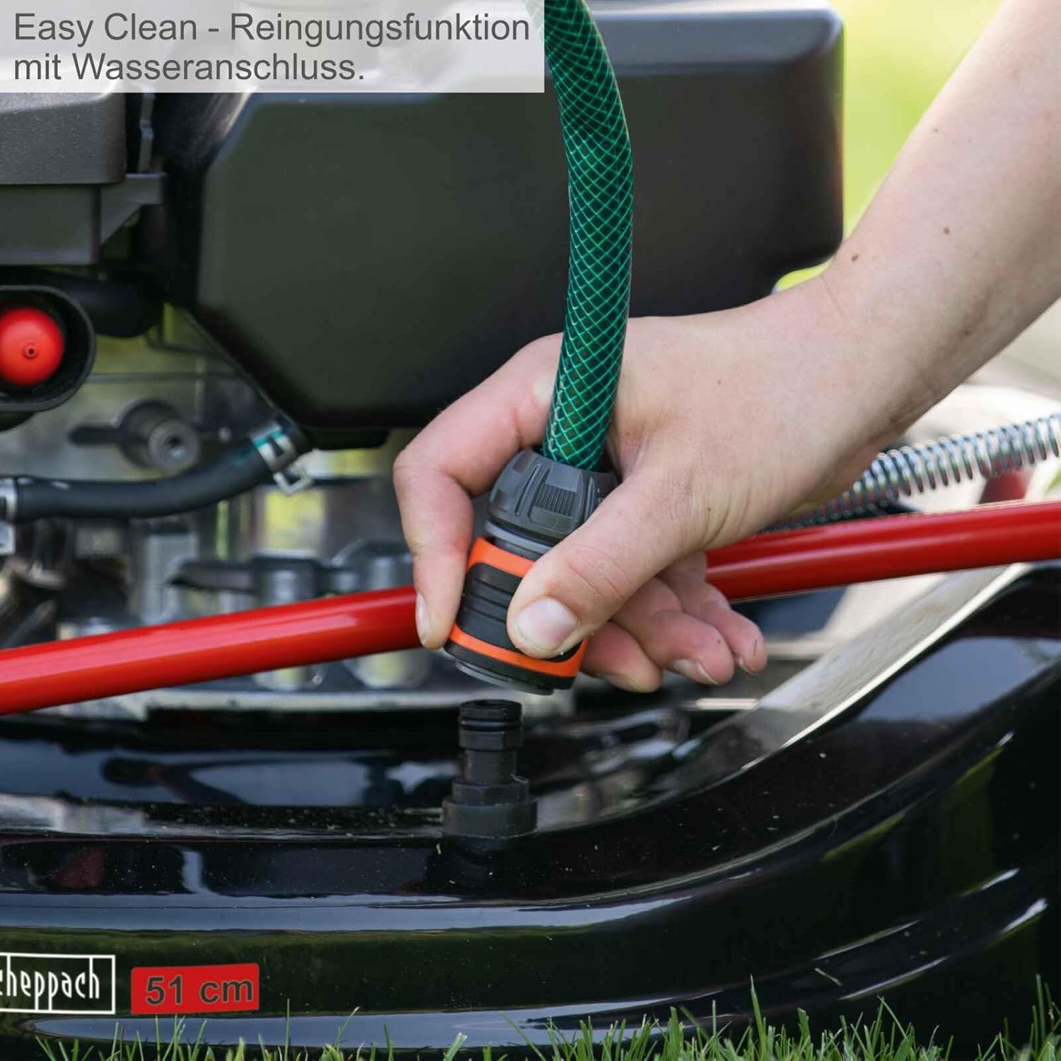 Hand connecting a water hose to the Easy Clean port on the lawnmower deck.