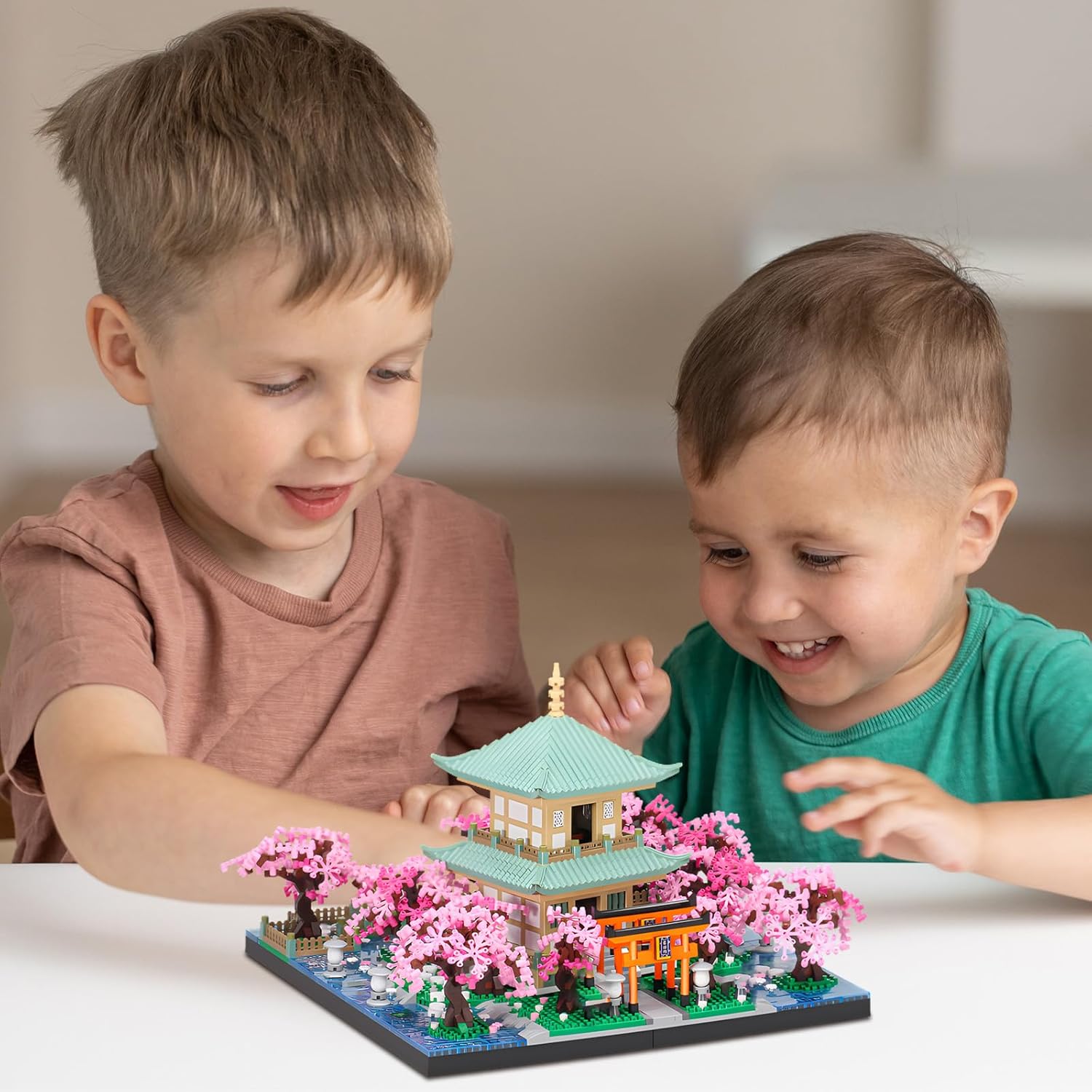 Two children observing the assembled HJPLPXH Cherry Blossom Tree House Micro Building Block Set.