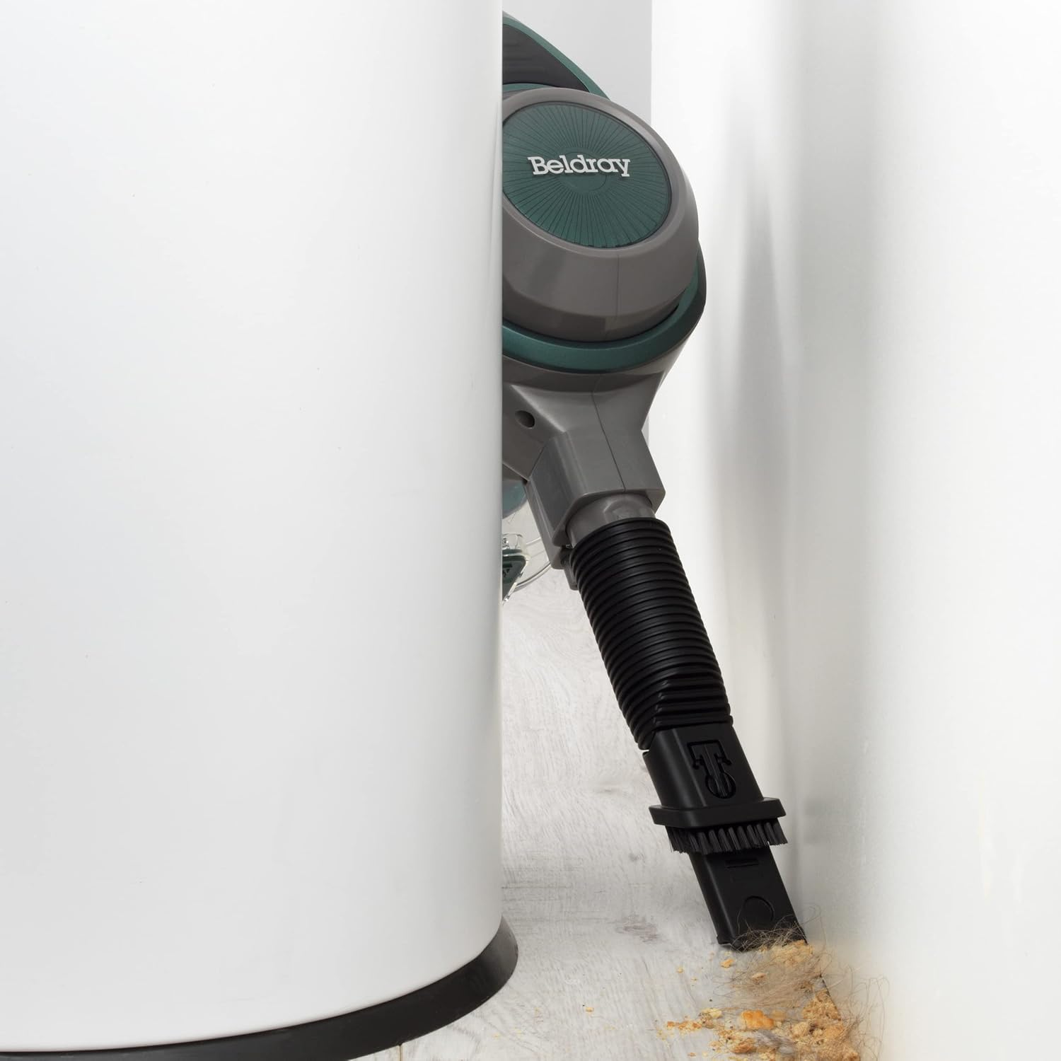 Handheld vacuum with crevice tool cleaning a tight corner