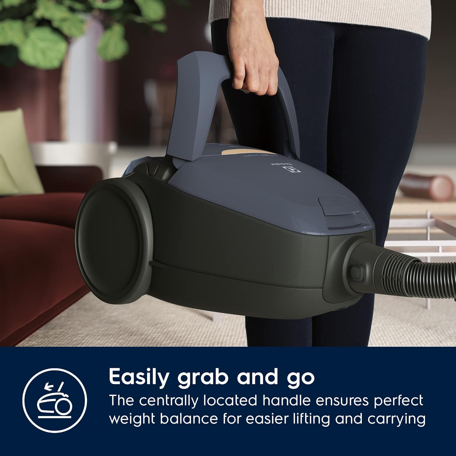 Person carrying the Electrolux Pure D8.2 Silence Vacuum Cleaner by its central handle