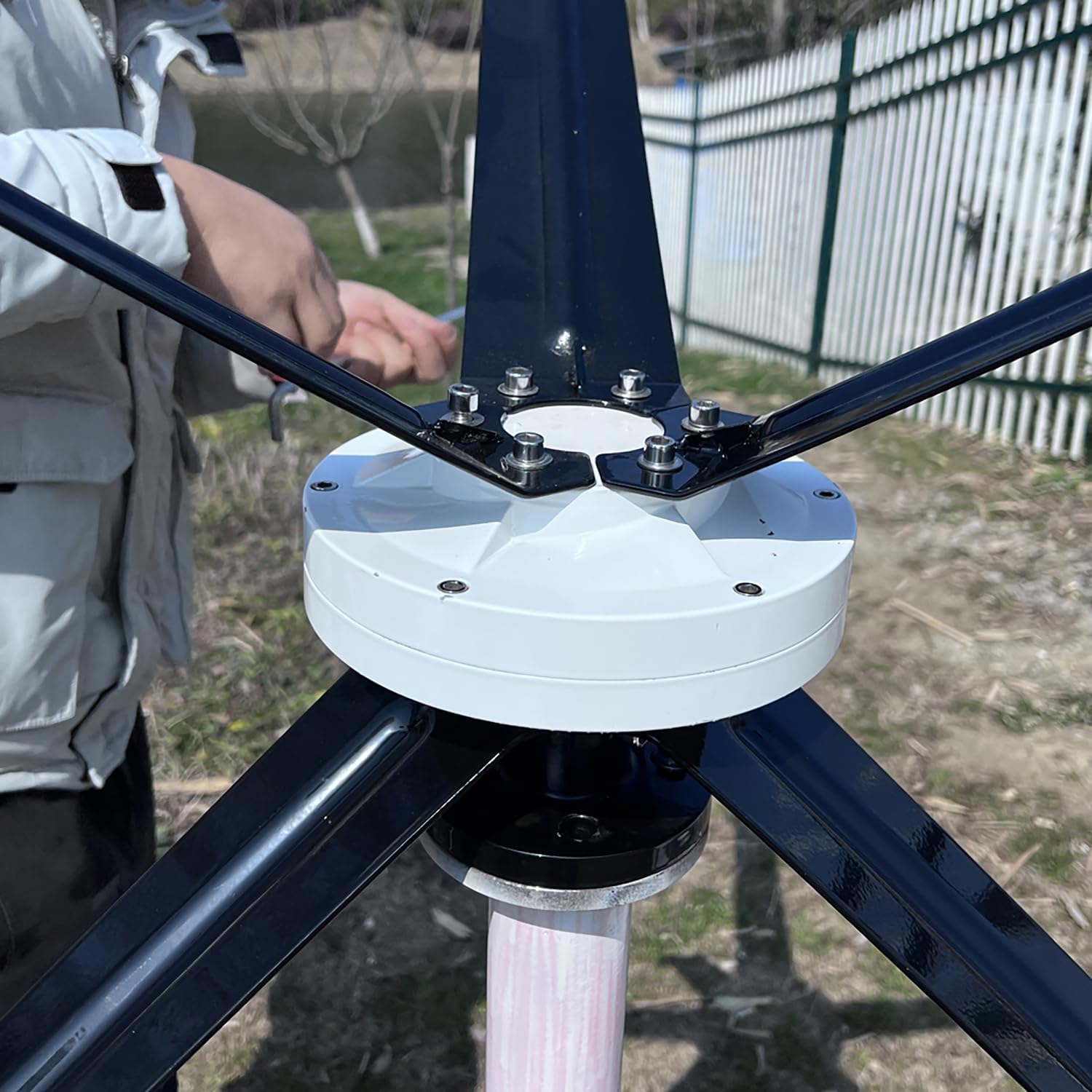 Close-up view of the wind turbine hub with blades being attached