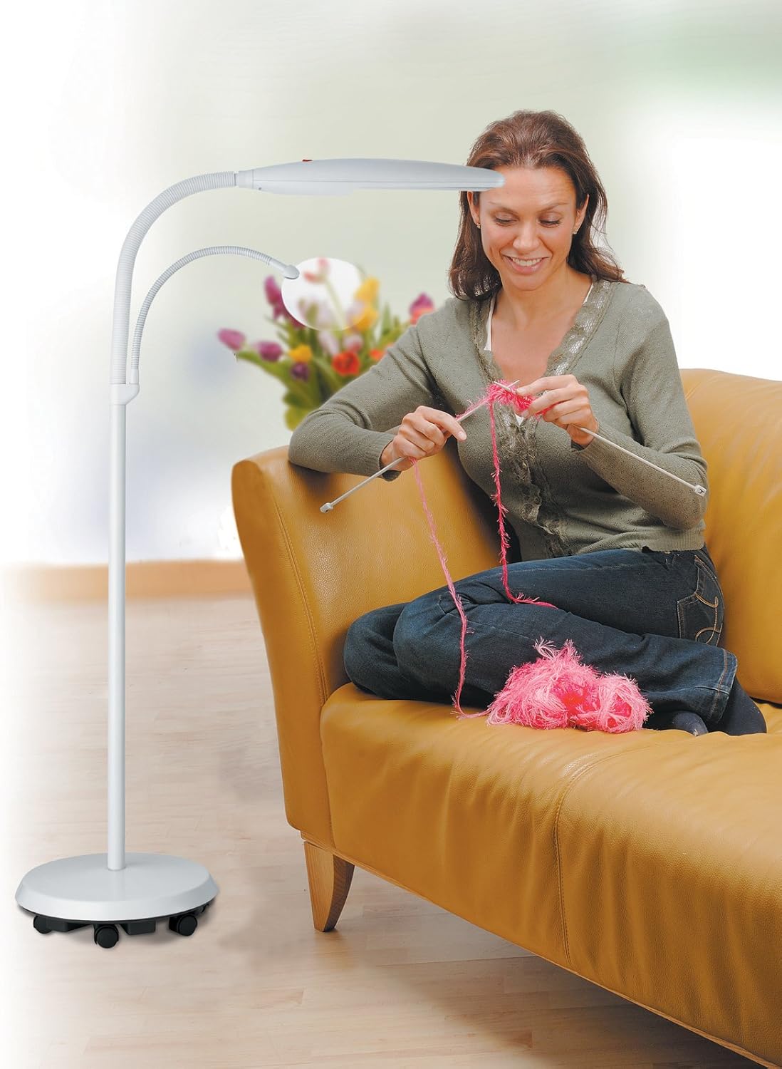 Woman knitting with the Daylight Swan Floor Lamp providing light and magnification for her craft.