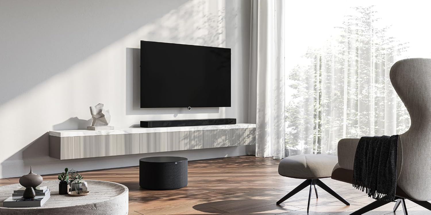 LOEWE klang bar5 mr soundbar and sub5 subwoofer placed in a modern living room setup with a television.