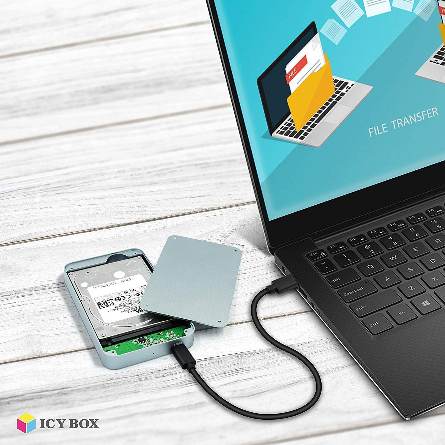 Laptop screen showing file transfer progress with the ICY BOX IB-247-C31 enclosure connected.