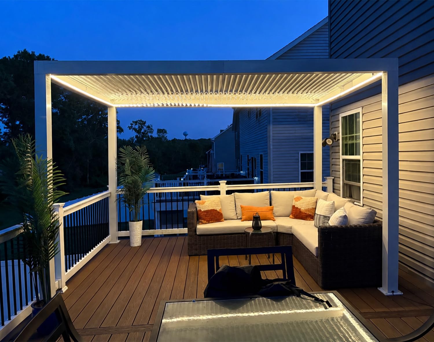 PURPLE LEAF 10' x 12' Louvered Pergola with LED Strip installed in an outdoor patio setting at dusk, with LED lights illuminated.