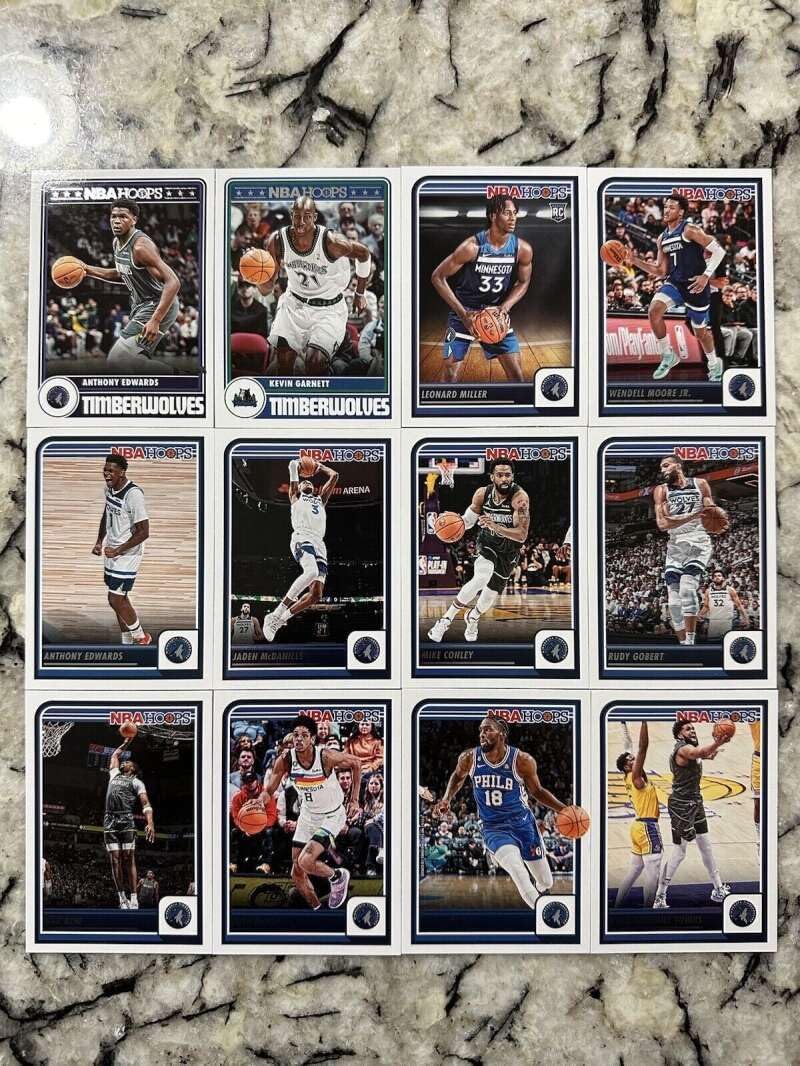 2023-24 Panini NBA Hoops Minnesota Timberwolves Team Set Includes Rookies (Hand Collated) of 12 Cards: #19 Karl-Anthony Towns 33 Shake Milton 47 Josh Minott 148 Naz Reid 153 Rudy Gobert 159 Mike Conley 170 Jaden McDaniels 189 Anthony Edwards 210 Wendell Moore Jr. 237 Leonard Miller RC 283 Kevin Garnett – Hoops Tribute 286 Anthony Edwards – Hoops Tribute
