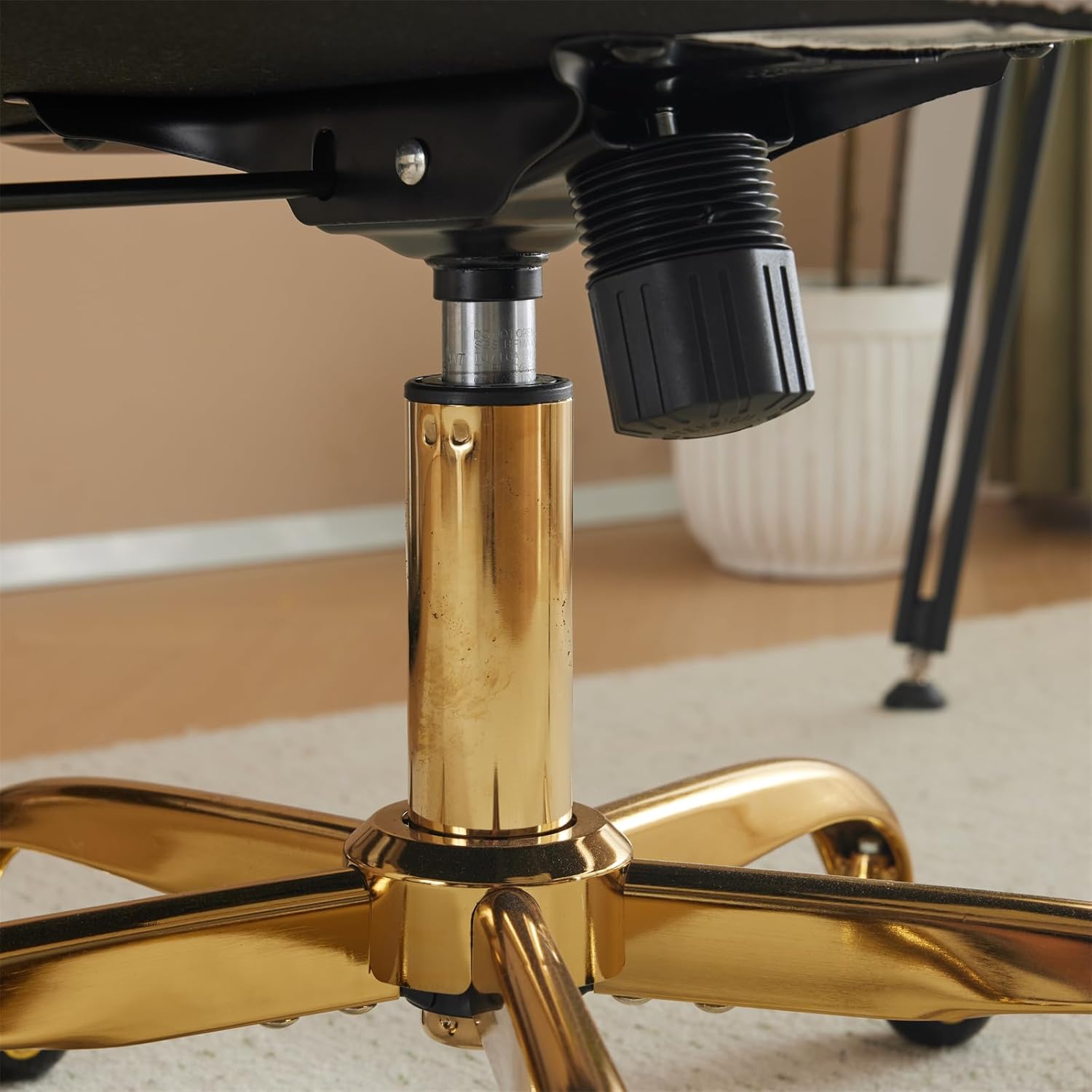 അടിവശം view of the chair seat showing the mechanism where the gas lift connects.