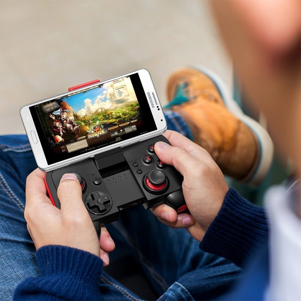 A person holding the Saitake BT 7002 Smartphone Joystick with a smartphone attached, playing a game.