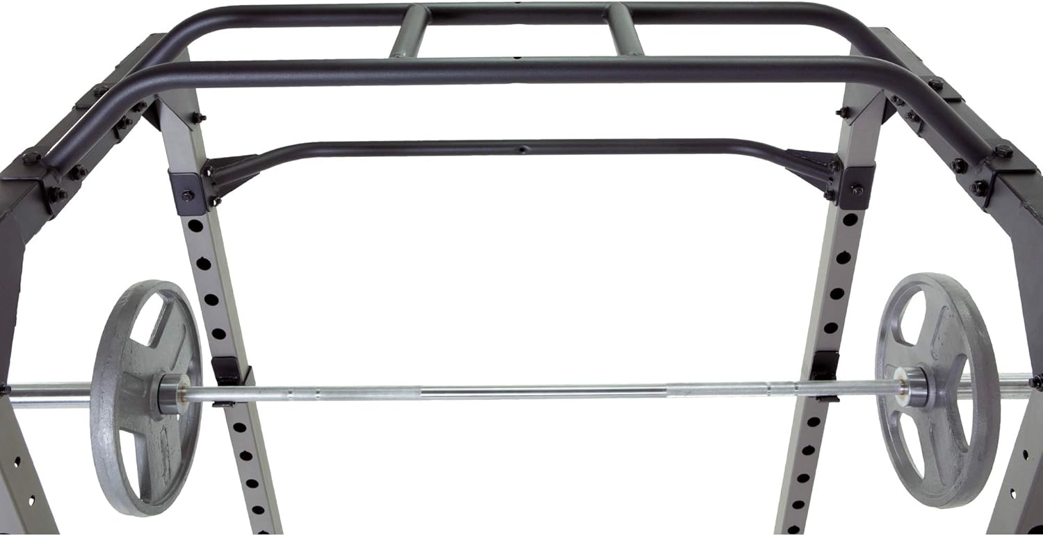Inside view of the power cage with a barbell resting on the J-hooks and safety bars visible