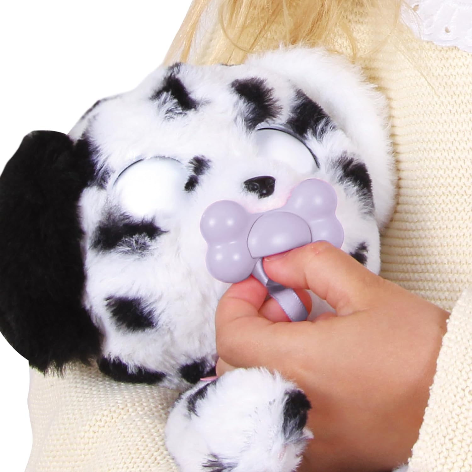 Hand inserting pacifier into Baby Paws Dalmatian Puppy, eyes closed