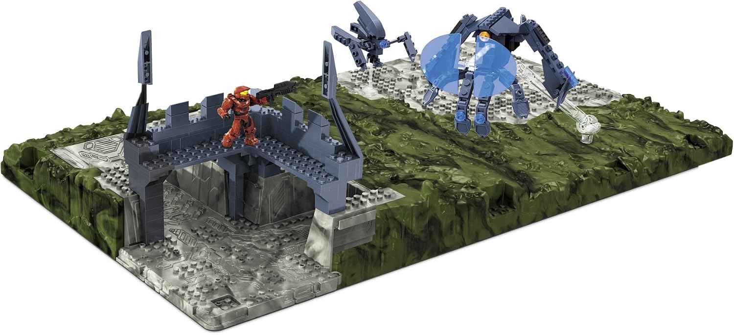 Mega Bloks Halo Battlescape III showing a red Spartan figure aiming a rifle, with a Forerunner Enforcer and two Sentinels in the background on a green and grey battlescape.