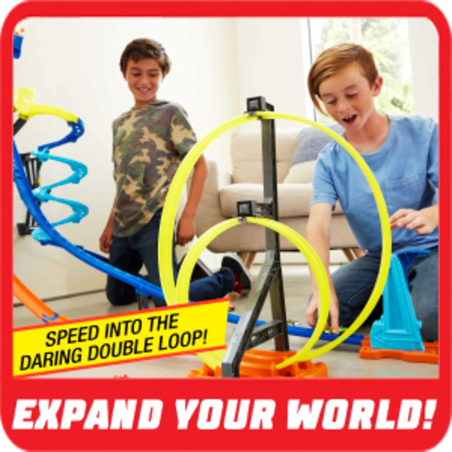 Two children playing with the Hot Wheels Track Builder Vertical Launch Kit, focusing on the double loop
