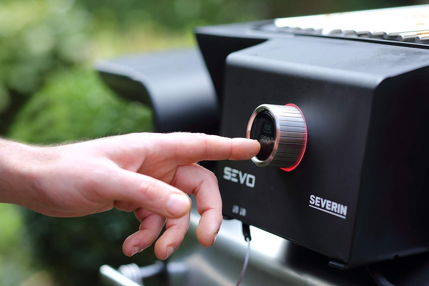 A hand adjusting the temperature dial on the Severin electric grill, showing the OLED display