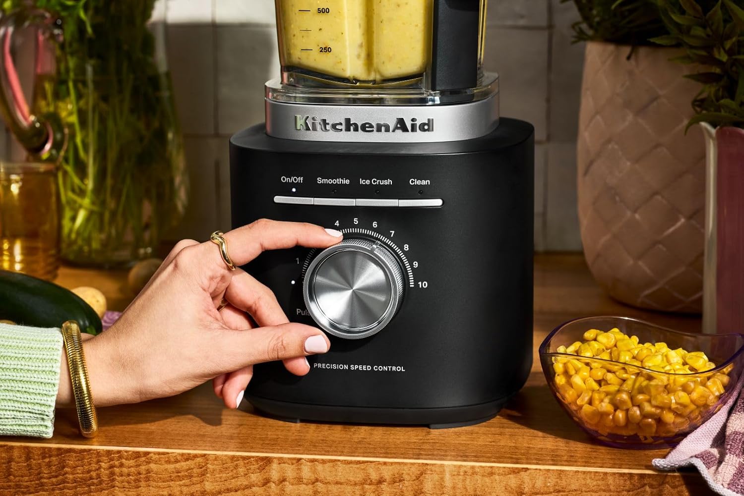 Hand adjusting the speed dial on KitchenAid blender