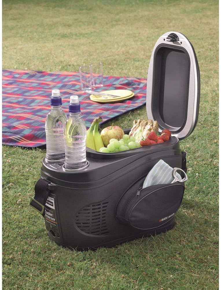 Black+Decker BDV212F cooler open, filled with fruits, sandwiches, and two water bottles, placed on a picnic blanket outdoors.