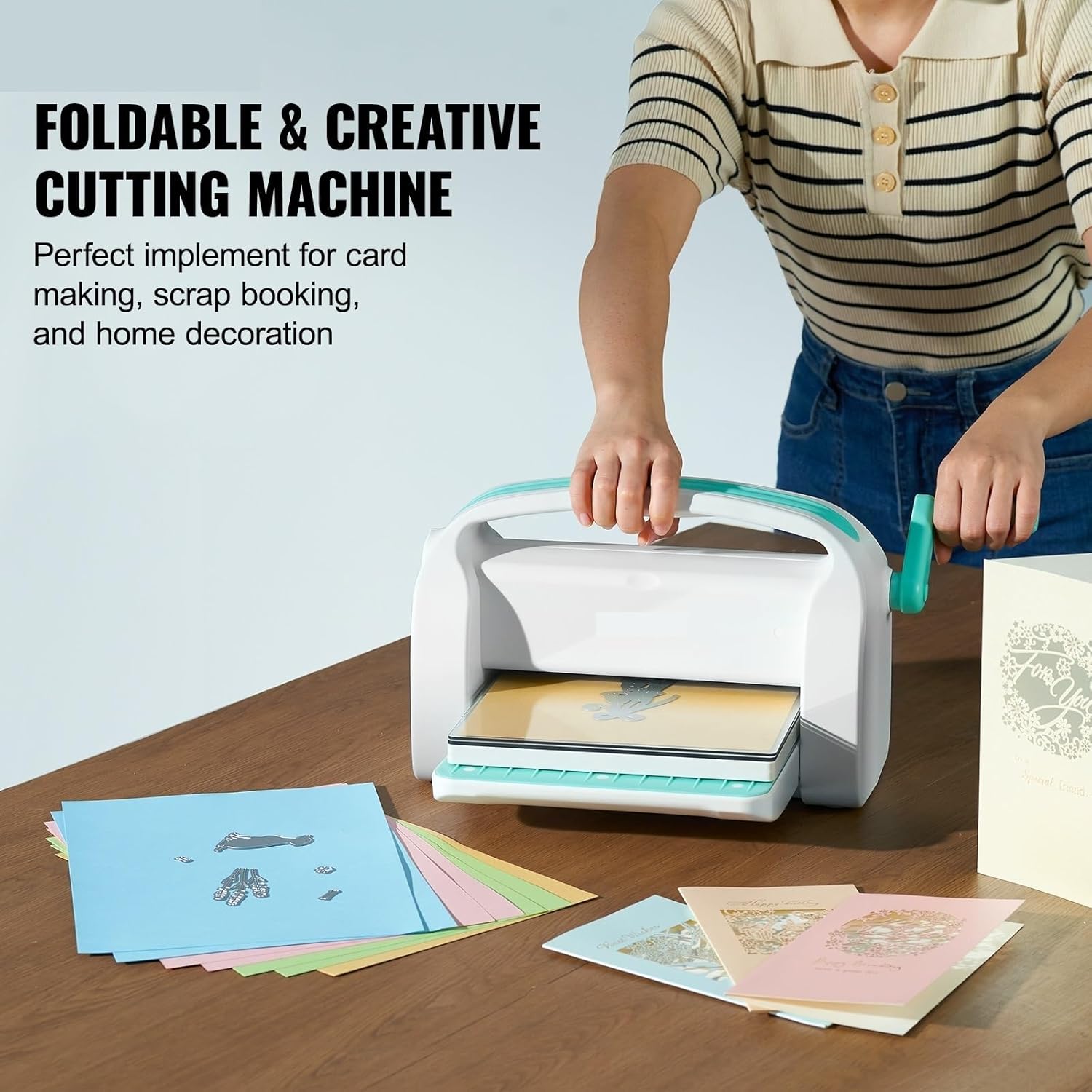 A person operating the MEIVIYA foldable die-cutting machine on a wooden table, with various paper crafts around.