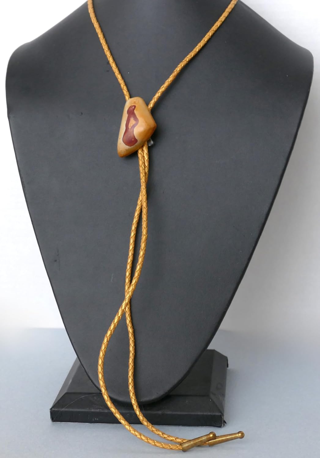 A Man's Red and Yellow Gemstone Bolo Tie With Gold Metallic Leather Cords and Gold Tone Tips