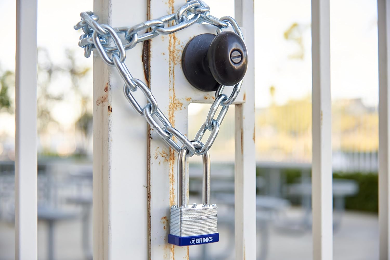 Brink's padlock securing a chain around a gate handle
