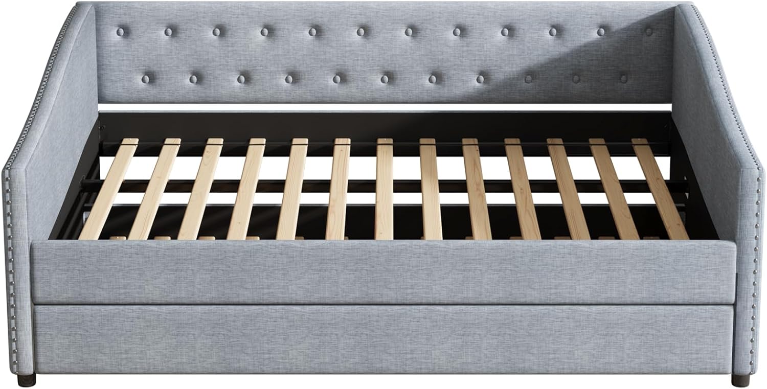 Front view of the assembled daybed frame with the trundle pushed in, showing the upholstered finish and button tufting.