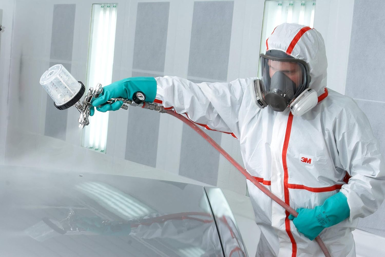 Worker wearing the 3M coverall and respirator while spray painting a car part