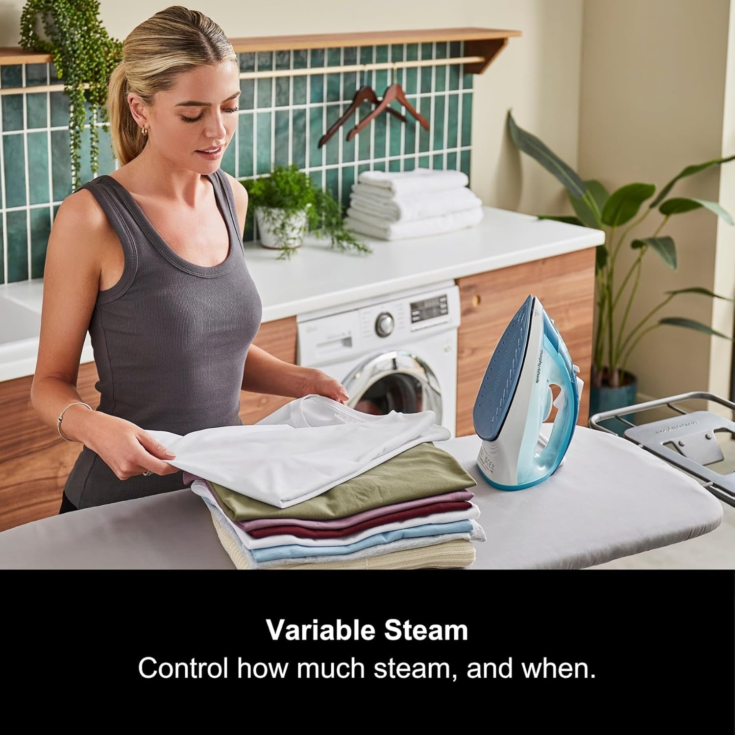 Person ironing a garment with variable steam