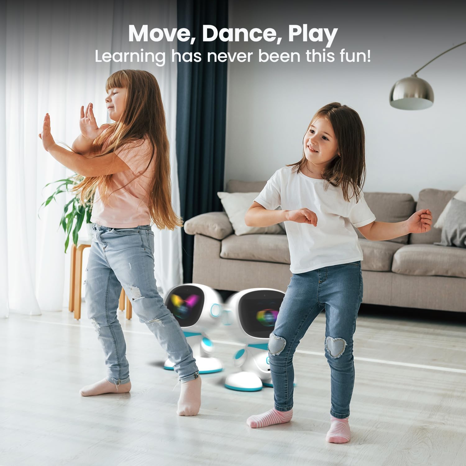 Dvě mladé dívky tančí v obývacím pokoji se dvěma roboty Misa 2 v pozadí.