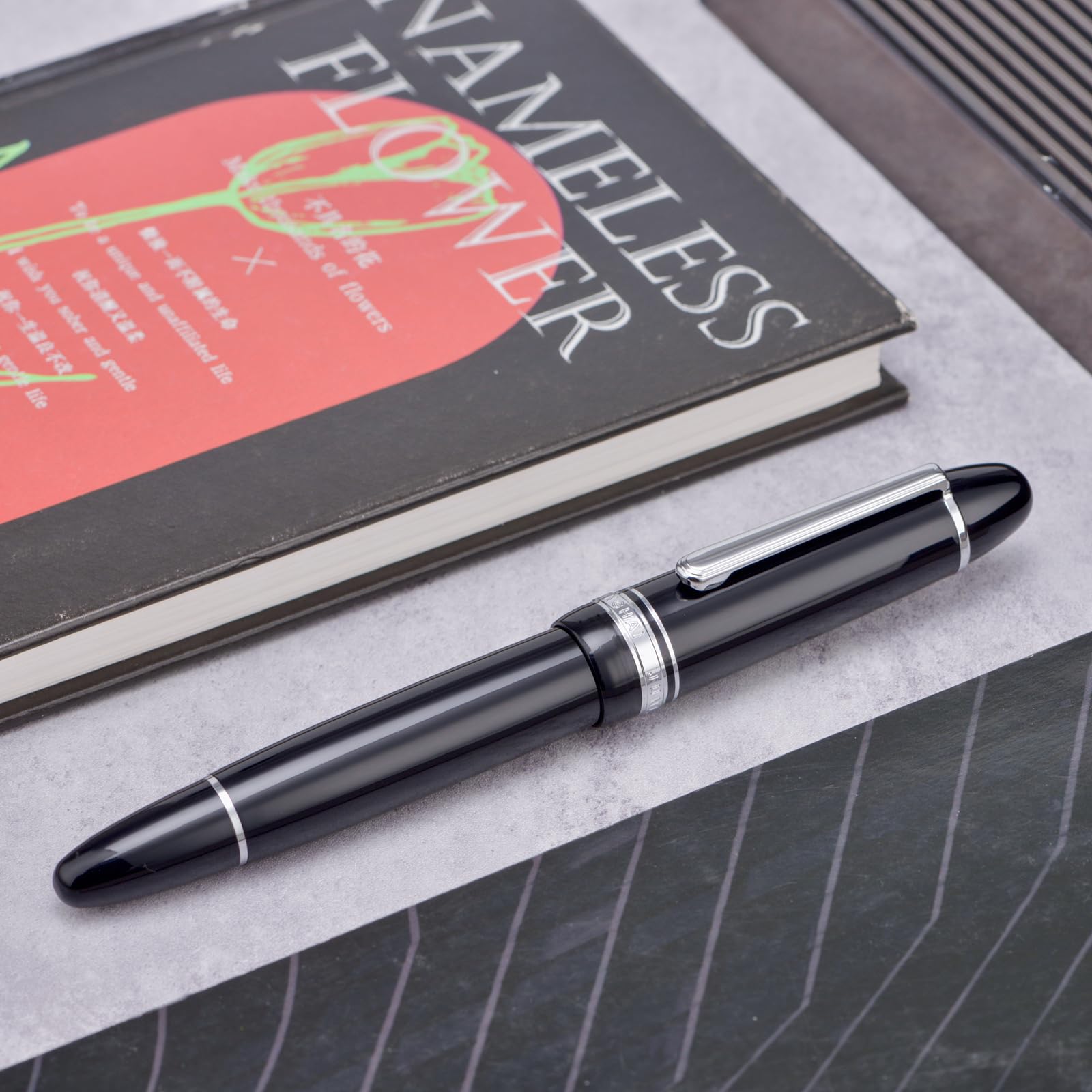 Yongsheng Junlai 930 - Pluma estilográfica acrílica, plumín mediano tamaño 9 con sistema de llenado de pistón, tanque de tinta de valla negro piano con diseño de forma de torpedo (Borde Plateado)