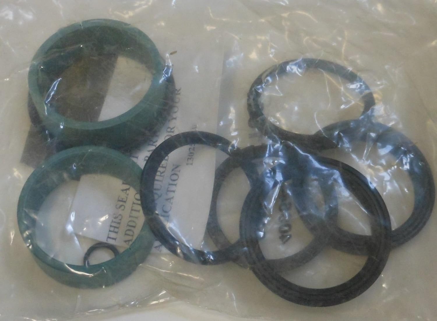 Contents of the Hyster Lift Cylinder Overhead Kit 337268 visible through clear plastic packaging, showing various black and teal-colored seals and rings.