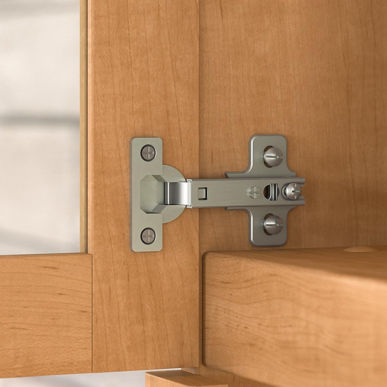 Close-up of a metal hinge used for the hutch's doors, showing its attachment to the wooden frame.
