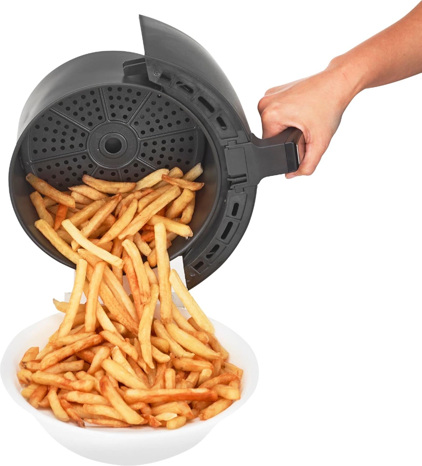 Hand pouring cooked french fries from the air fryer basket into a bowl