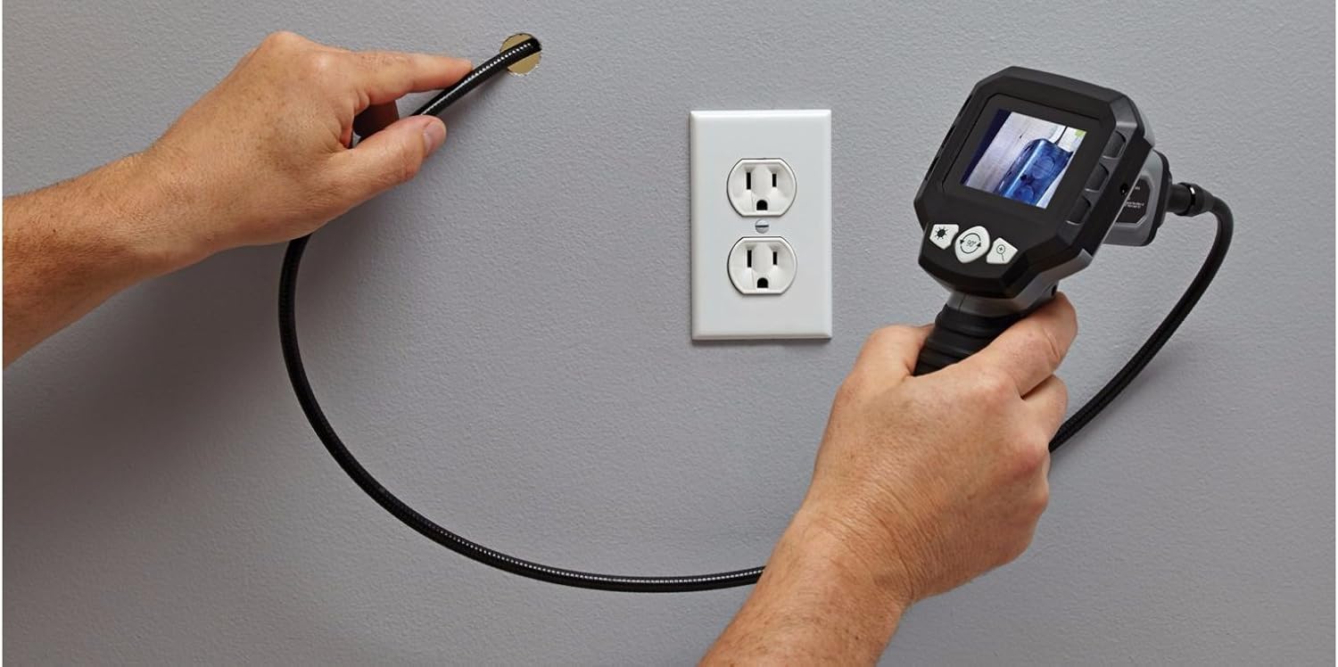 Using the inspection camera to view inside a wall cavity near an electrical outlet.