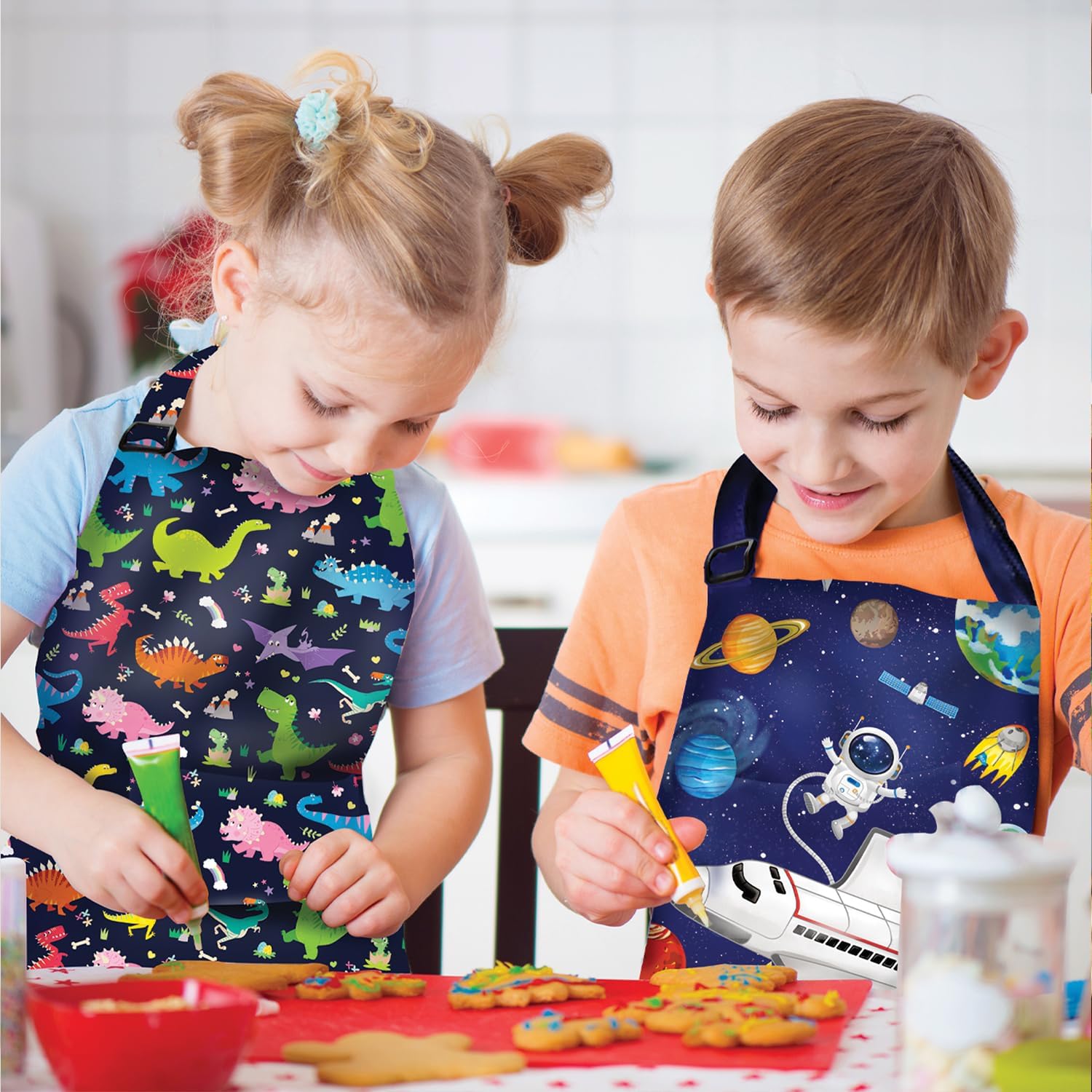 DECOWALL Kids Apron 2 Pack–Dinosaurs, Space Planets for Boys Girls Chef Kitchen Aprons Front Pocket Cooking Baking Painting Adjustable Strap Dinosaurs, Space Planets, Standard, Blue (APS-202)