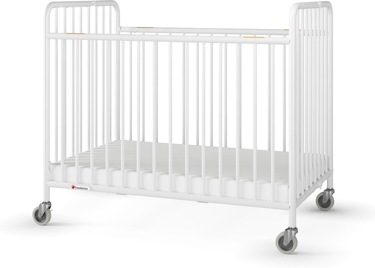 Cuna de hotel plegable de metal para bebés y niños pequeños Foundations Stowaway, color blanco | Cuna portátil con colchón de espuma de 2" y ruedas comerciales, fácil plegado y almacenamiento compacto para hoteles