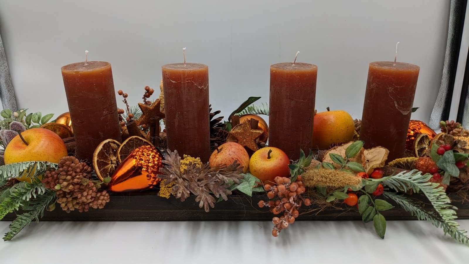 Weihnachtsgesteck Tischgesteck Apfel Orangenscheibe Zapfen Kerzen orange