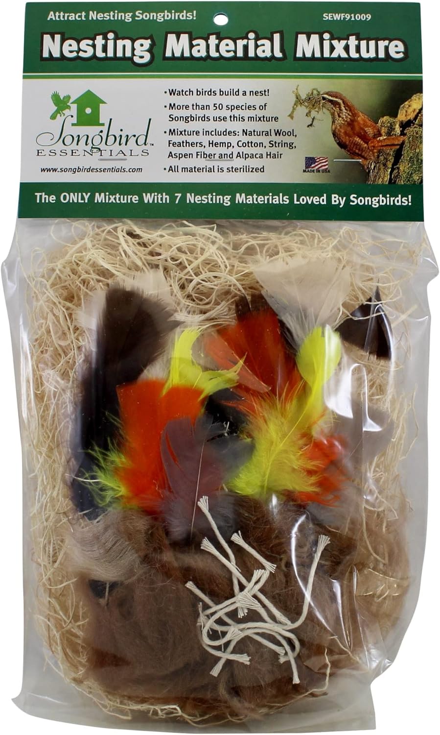 A wire ball holder filled with natural cotton nesting material hanging from a branch.