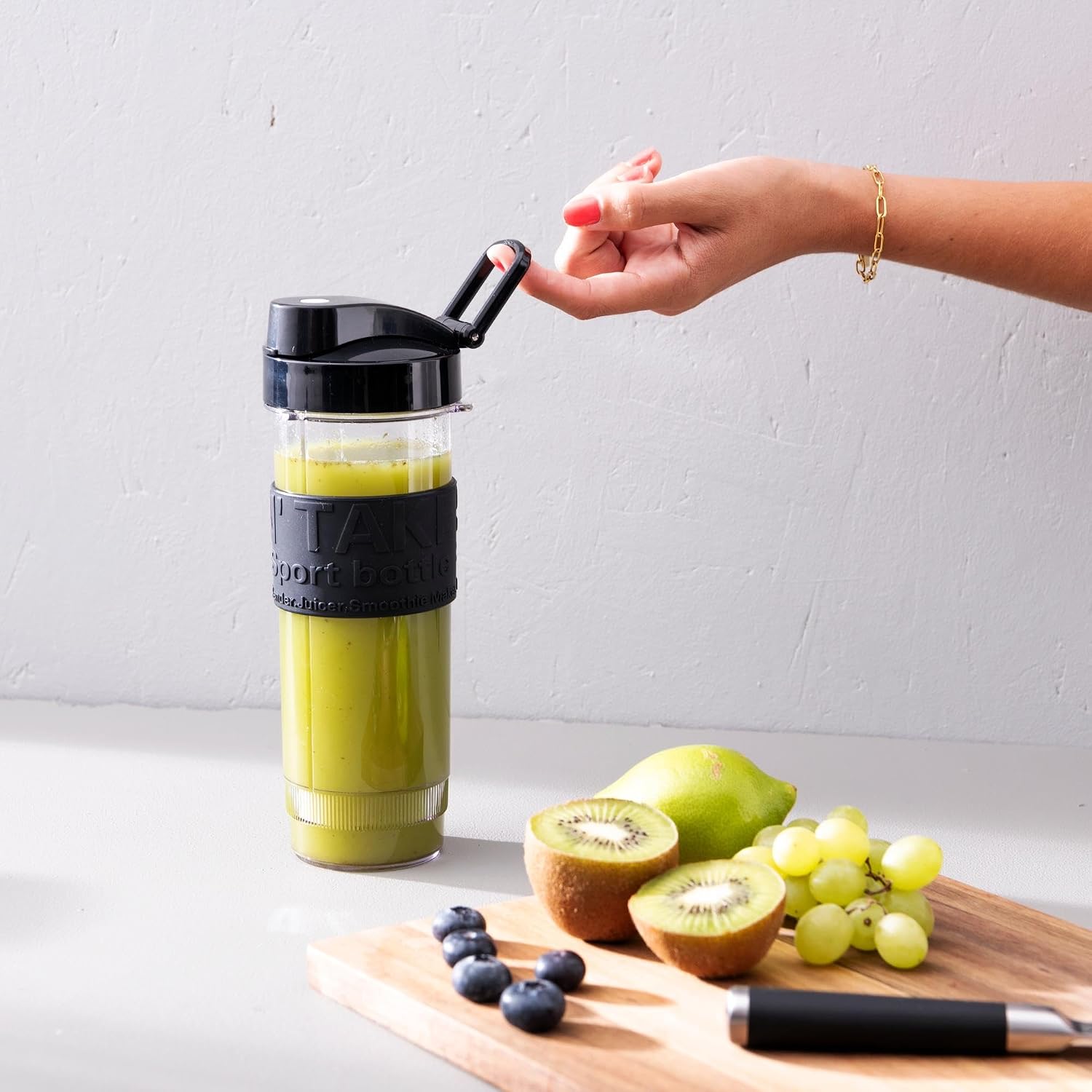 Blended green smoothie in bottle with lid open