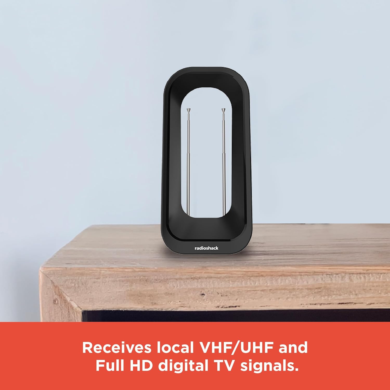 RadioShack Digital Indoor Antenna placed on a wooden surface in a room, demonstrating its compact size and placement flexibility.